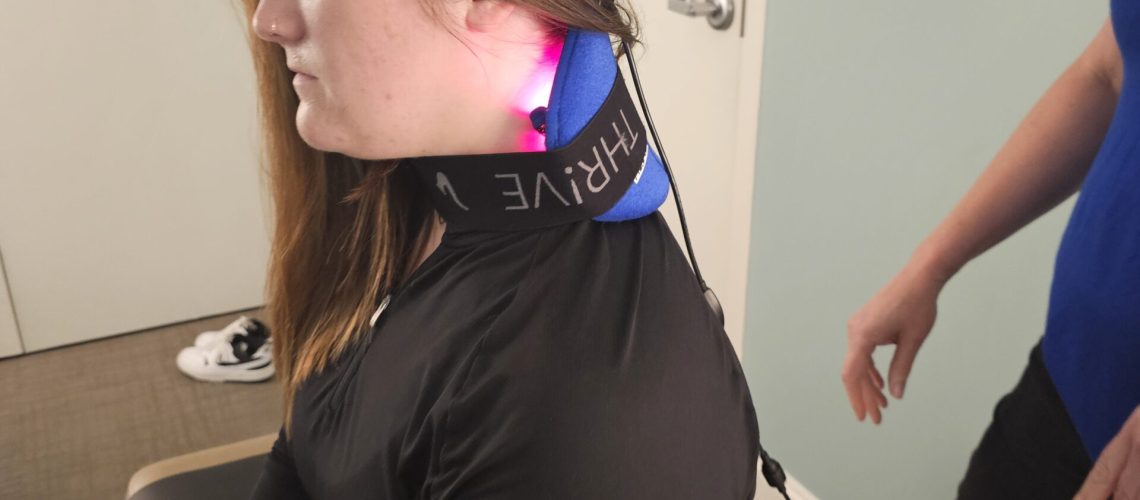 a woman sitting with a laser therapy device on to ease her pain